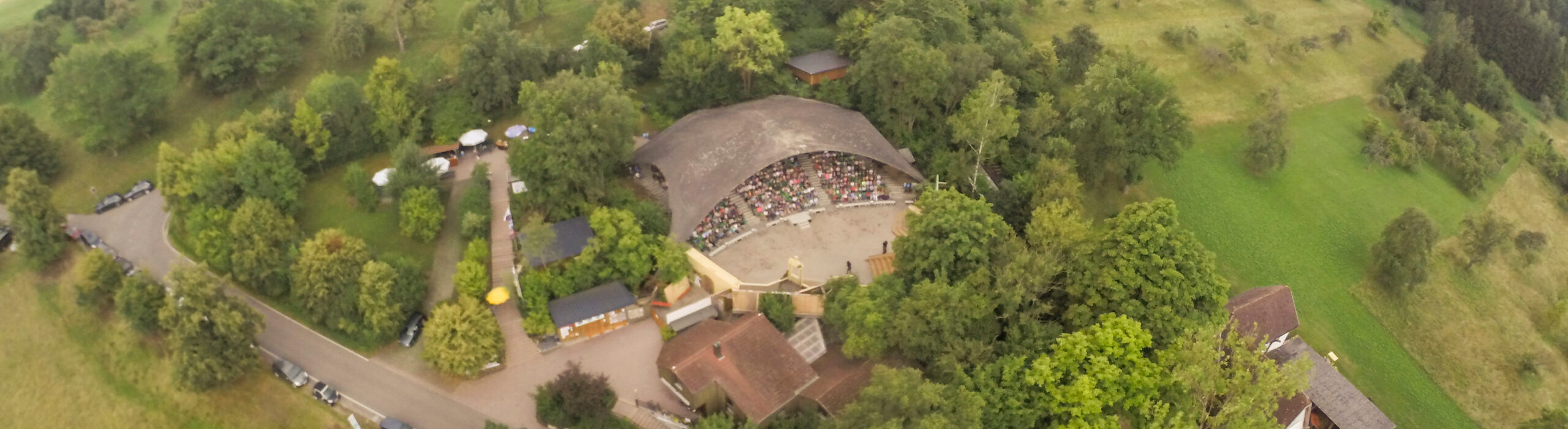 Das Naturtheater Grötzingen aus der Luft. Zentral im Vordergrund das Spielerheim und die Bühne, In der Mitte die Kuppel, die den Zuschauerraum für 880 Personen überspannt